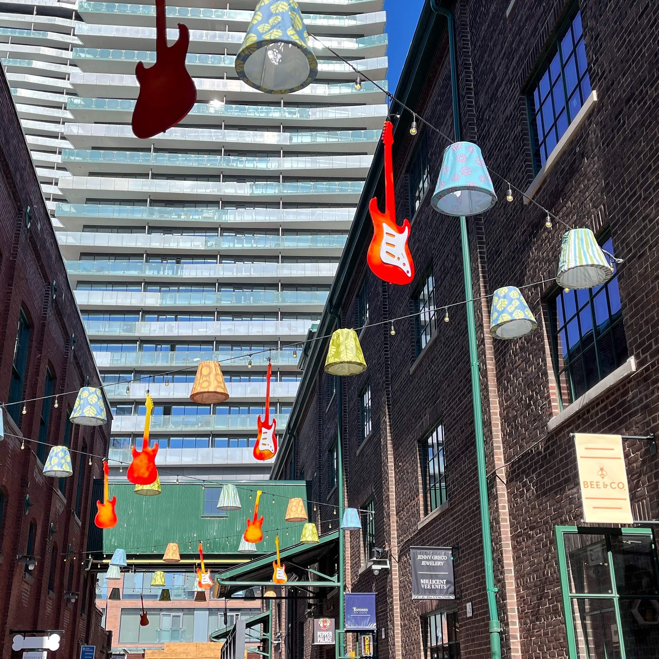 Guitars up in air and buildings in Distillery District in Toronto.