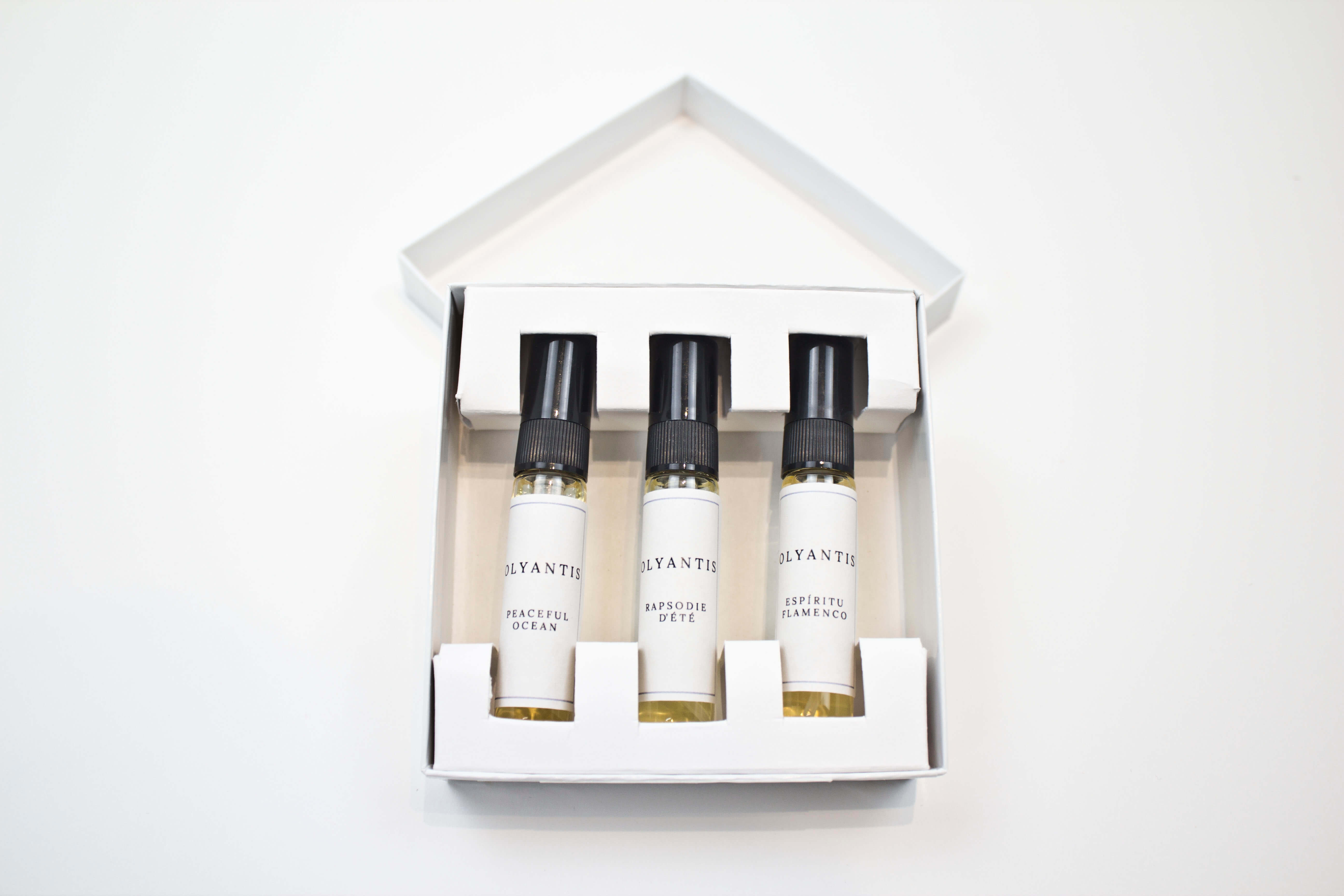 Olyantis's Discovery set  containing three 5 ml sample bottles with black caps and white labels, arranged inside a white square-shaped box on a clean white background.