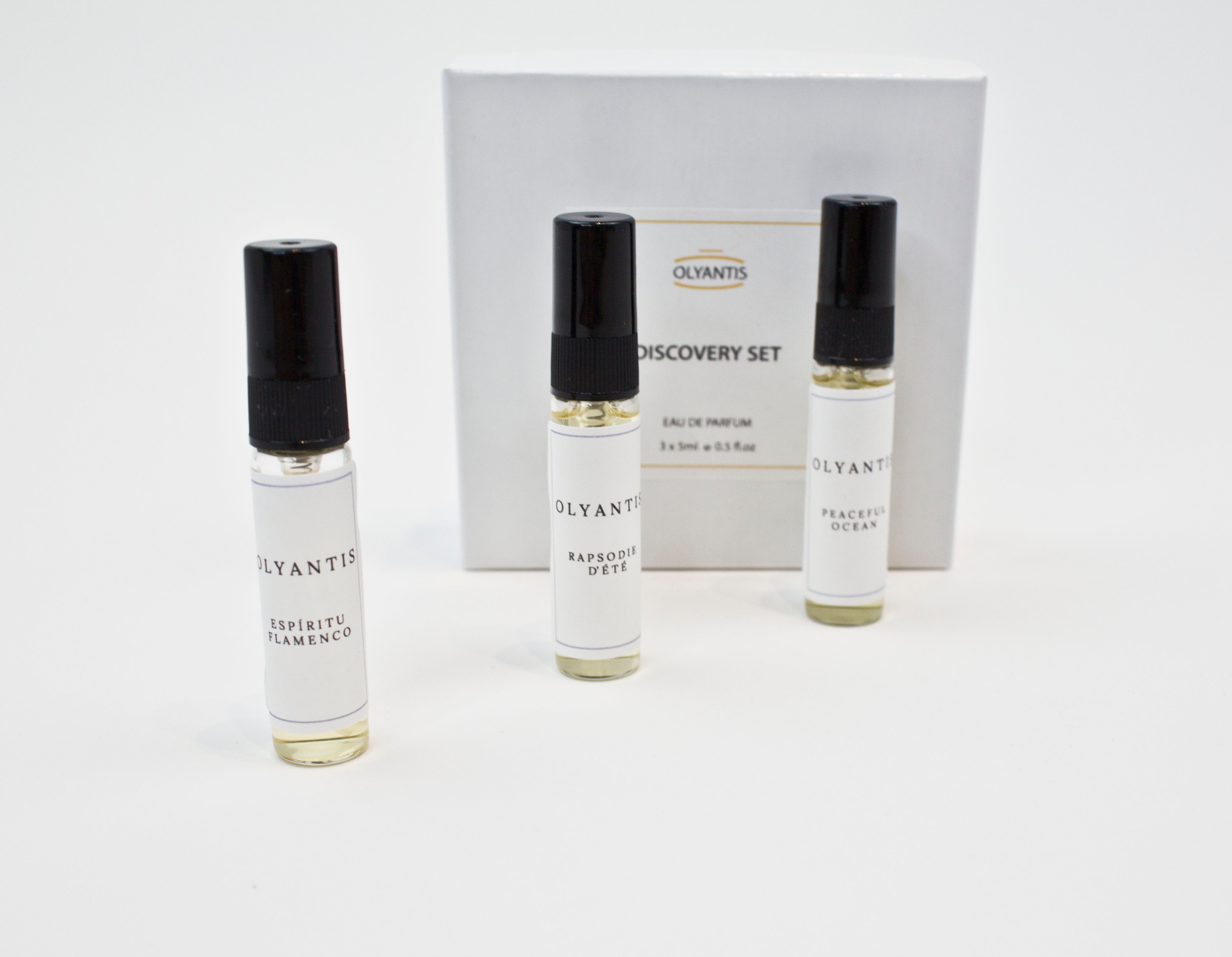 Olyantis's Discovery Set of 3x 5 ml perfume glass bottles, spaced, standing up in front of its white box. 