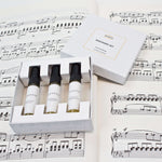 Olyantis's Discovery Set of 3x 5 ml perfume glass bottles with the white box opened, on one of Mendelsson’s score opened. 