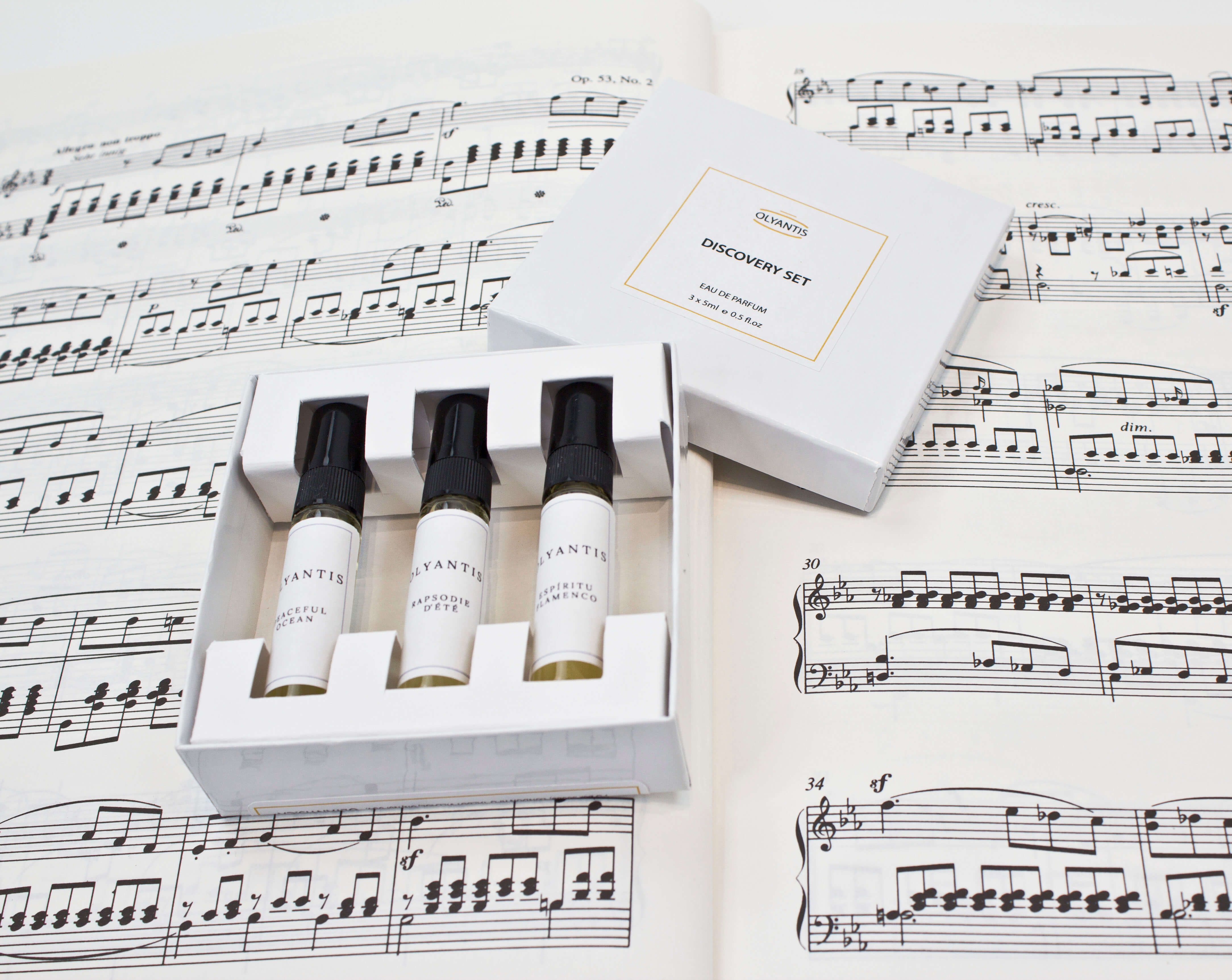 Olyantis's Discovery Set of 3x 5 ml perfume glass bottles with the white box opened, on one of Mendelsson’s score opened. 