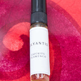 Olyantis's Espíritu Flamenco 5 ml perfume glass bottle on a red-burgundy colorful background.