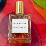 Olyantis's Espíritu Flamenco 60 ml perfume glass bottle on a red-burgundy colorful background.