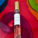 Olyantis's Espíritu Flamenco 10 ml perfume glass bottle with gold cap on a red-burgundy colorful background.