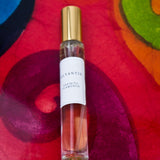 Olyantis's Espíritu Flamenco 10 ml perfume glass bottle with gold cap on a red-burgundy colorful background.
