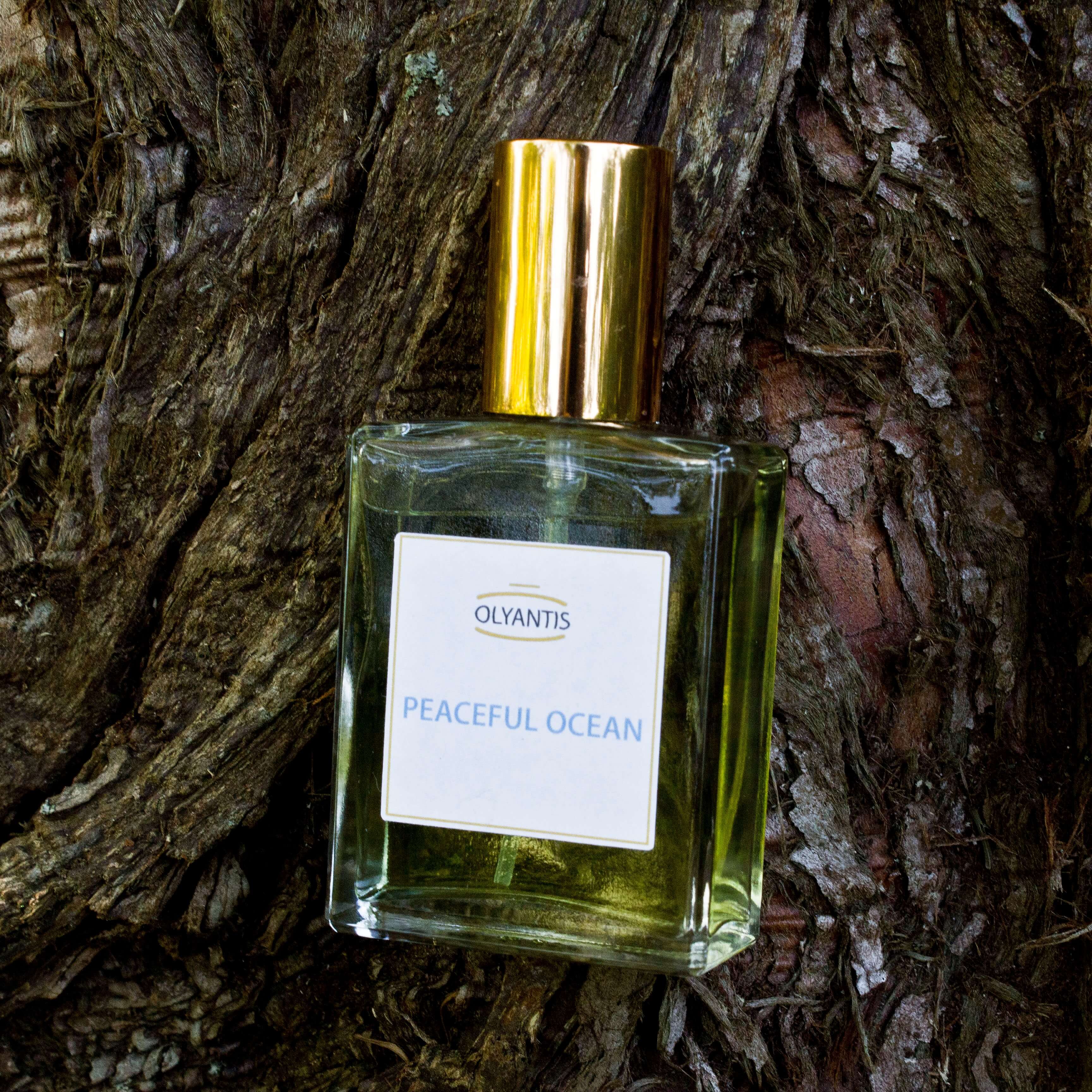 Olyantis 60 ml Peaceful Ocean eau de parfum bottle on a majestic tree background. 