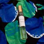 Olyantis's Peaceful Ocean 10 ml perfume glass bottle with gold cap on the intense blue and green background. 