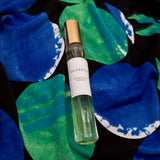Olyantis's Peaceful Ocean 10 ml perfume glass bottle with gold cap on the intense blue and green background. 