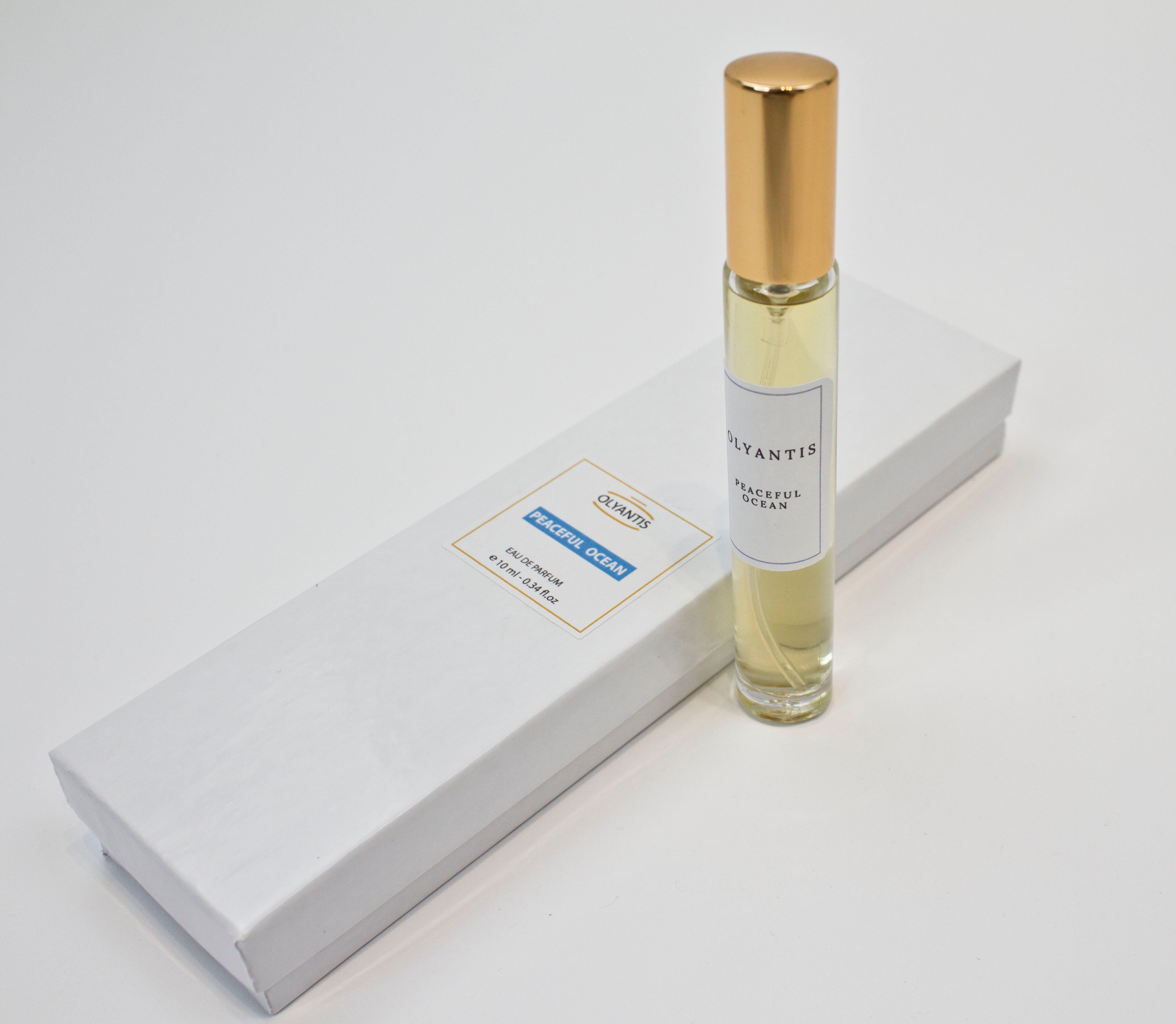 Olyantis's Peaceful Ocean 10 ml perfume glass bottle with gold cap beside its paper box. 