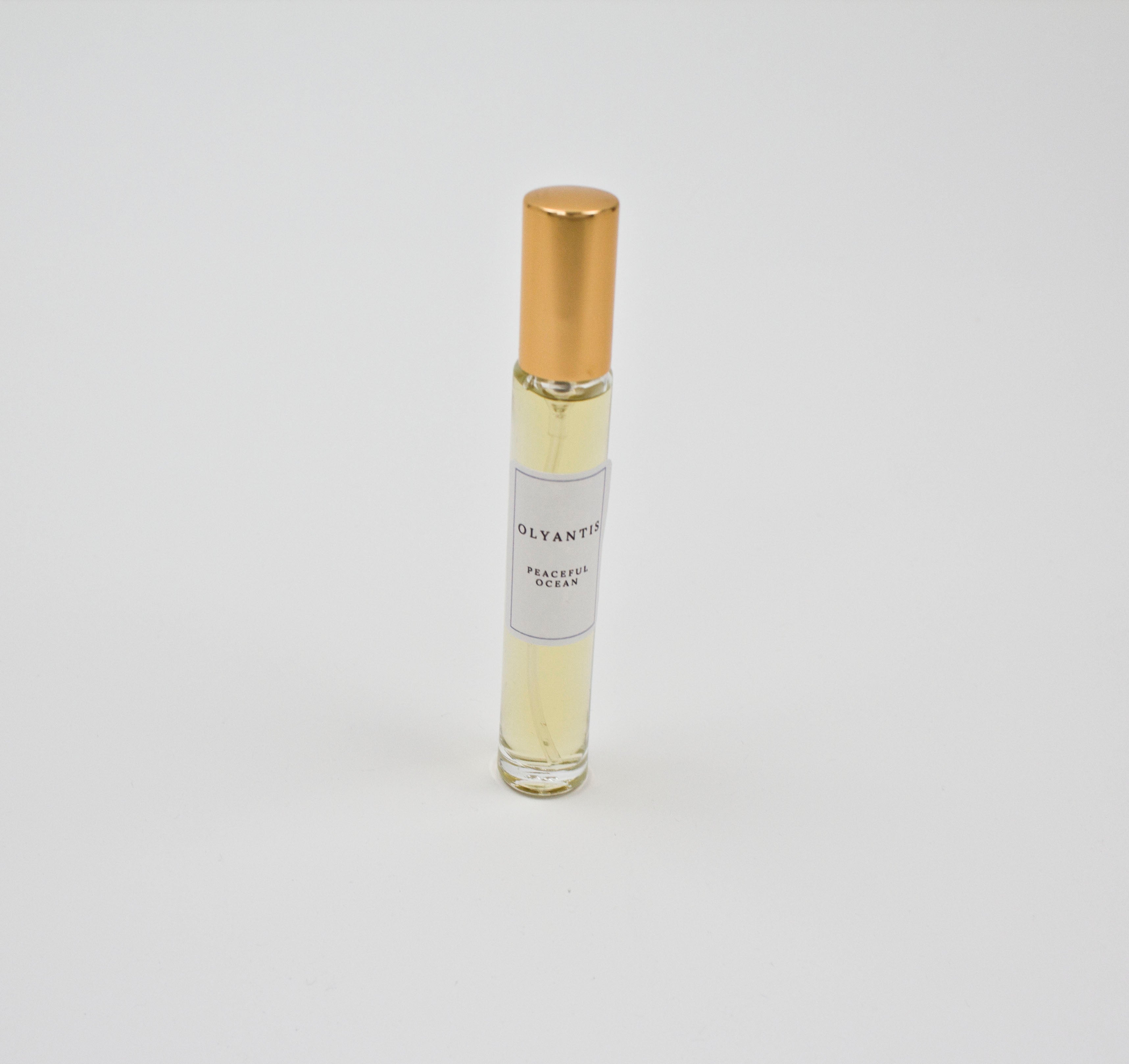 Olyantis's Peaceful Ocean 10 ml perfume glass bottle with gold cap on a white background. 