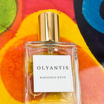 Olyantis's  Rapsodie D'Été 60 ml perfume glass bottle on the orange, colorful background.