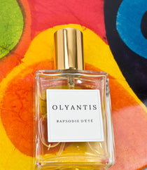 Olyantis's  Rapsodie D'Été 60 ml perfume glass bottle on the orange, colorful background.