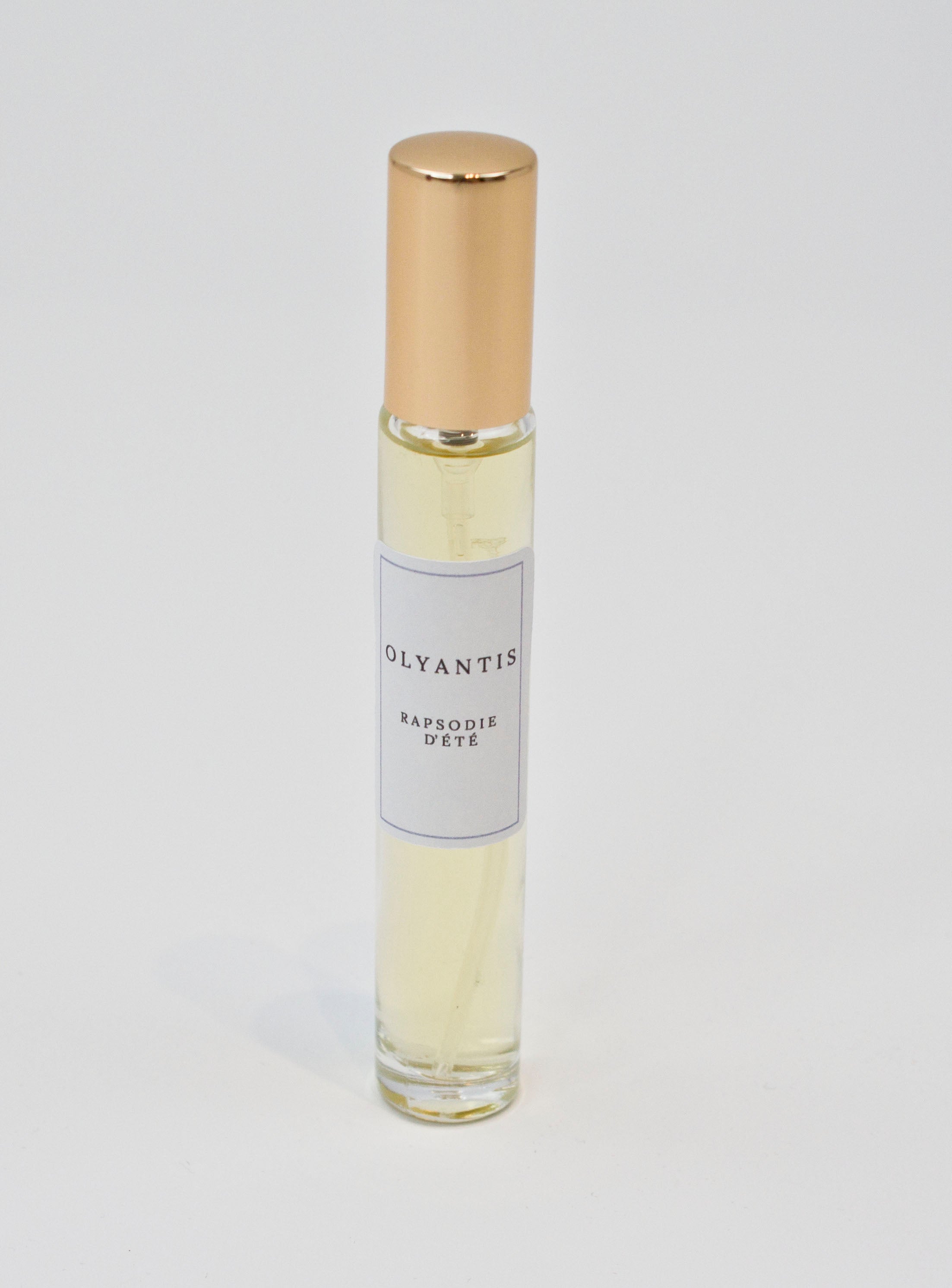 Olyantis's  Rapsodie D'Été 10 ml perfume glass bottle with gold cap on a white background.