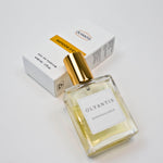 Olyantis's  Rapsodie D'Été 60 ml perfume glass bottle with gold cap beside its paper box.