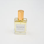 Olyantis's  Rapsodie D'Été 60 ml perfume glass bottle with gold cap on a white background.