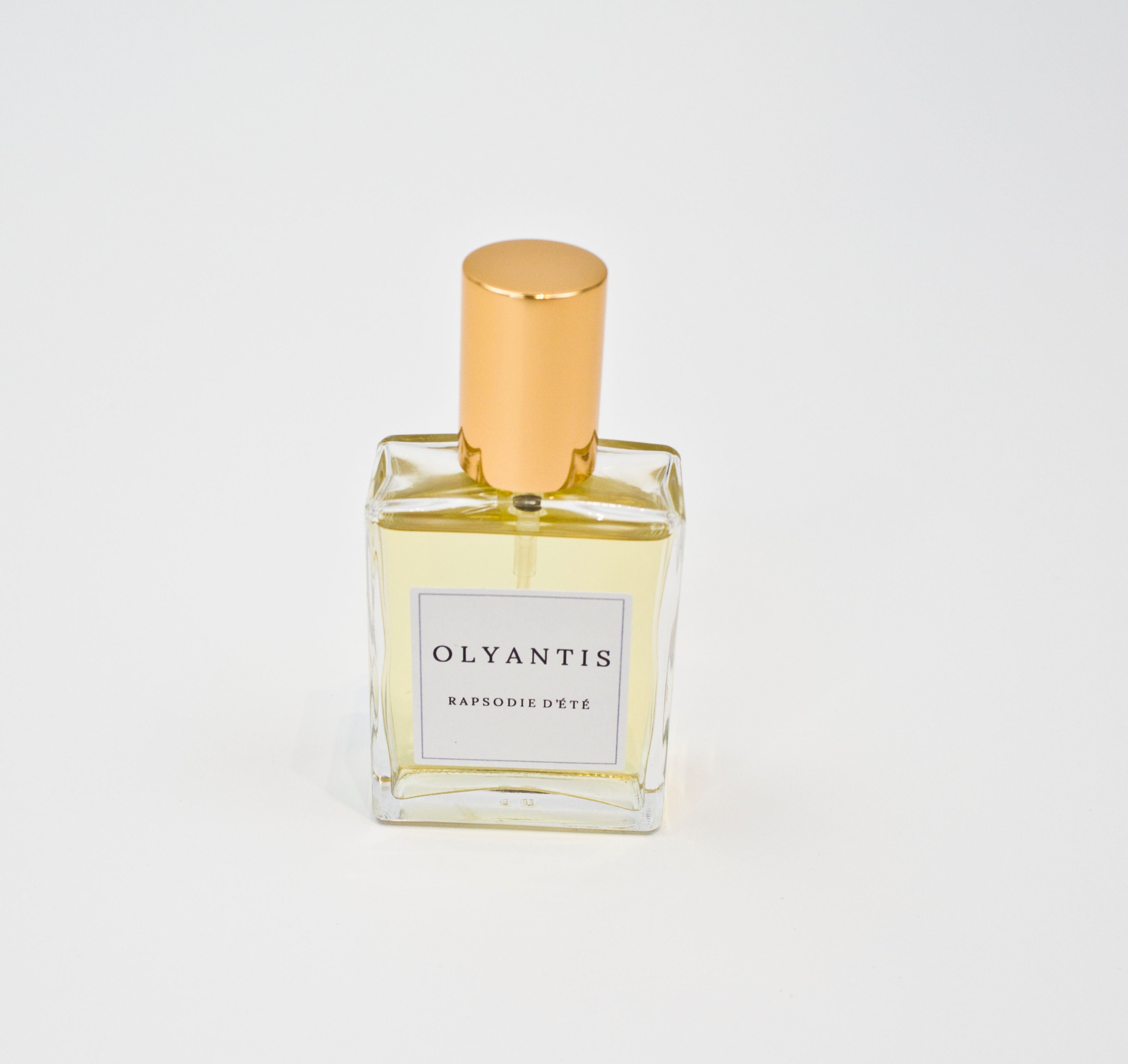 Olyantis's  Rapsodie D'Été 60 ml perfume glass bottle with gold cap on a white background.