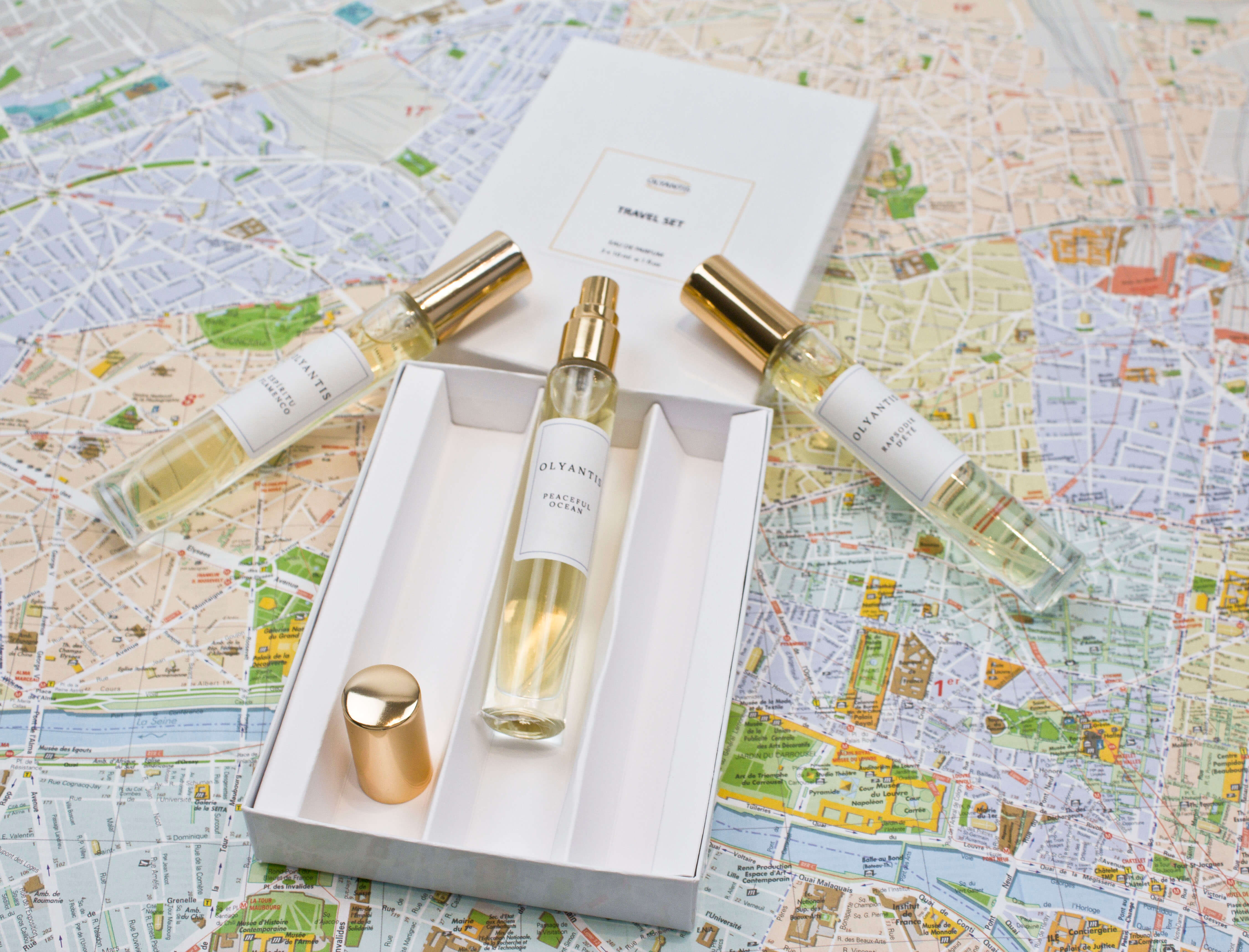 Olyantis's Travel Set of 3x 10 ml perfume glass bottles, on with golden cap off, in its opened box, on Montpellier’s ( France) city map. 